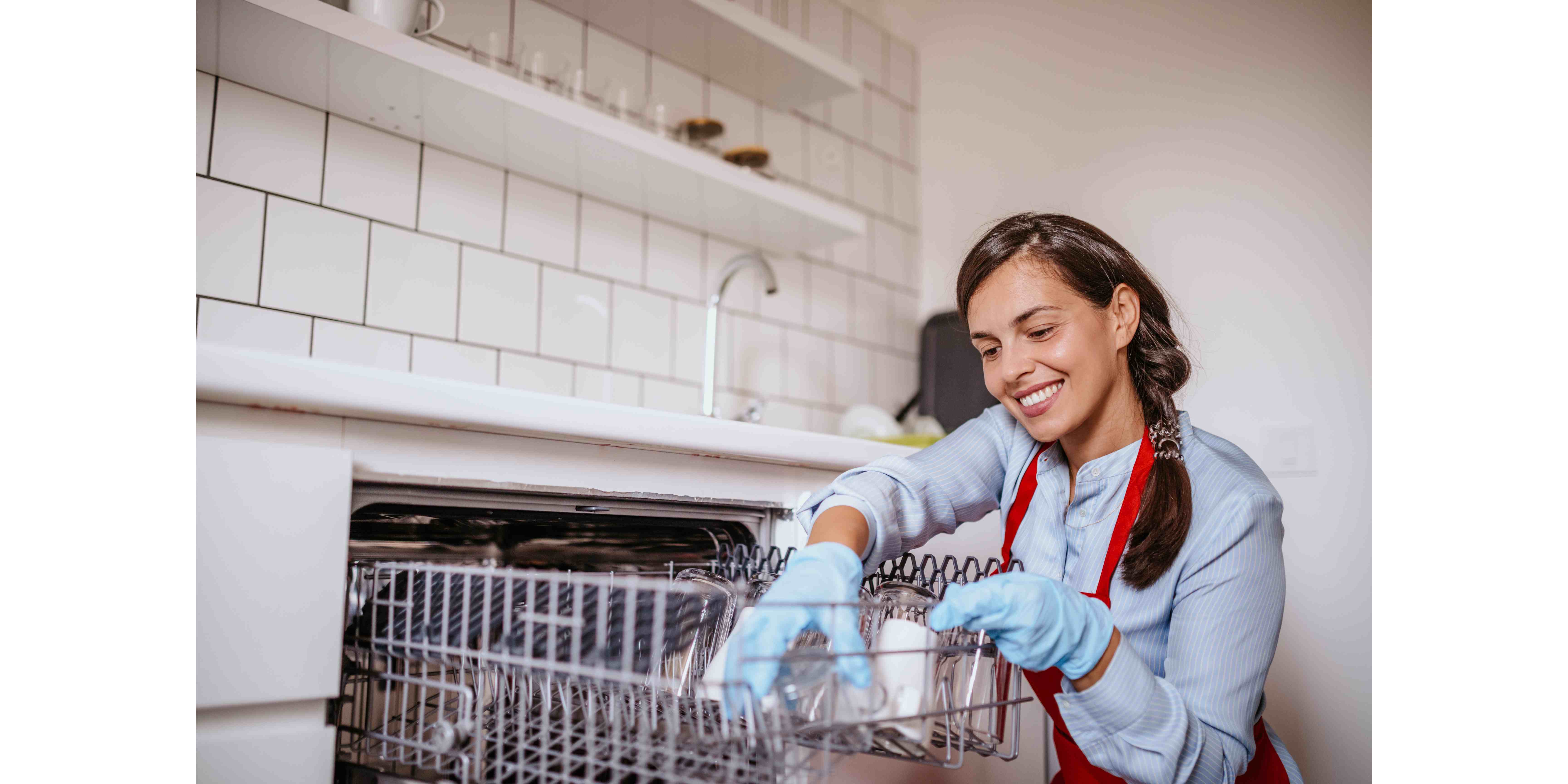 a woman smiling while cleaning a dishwasher