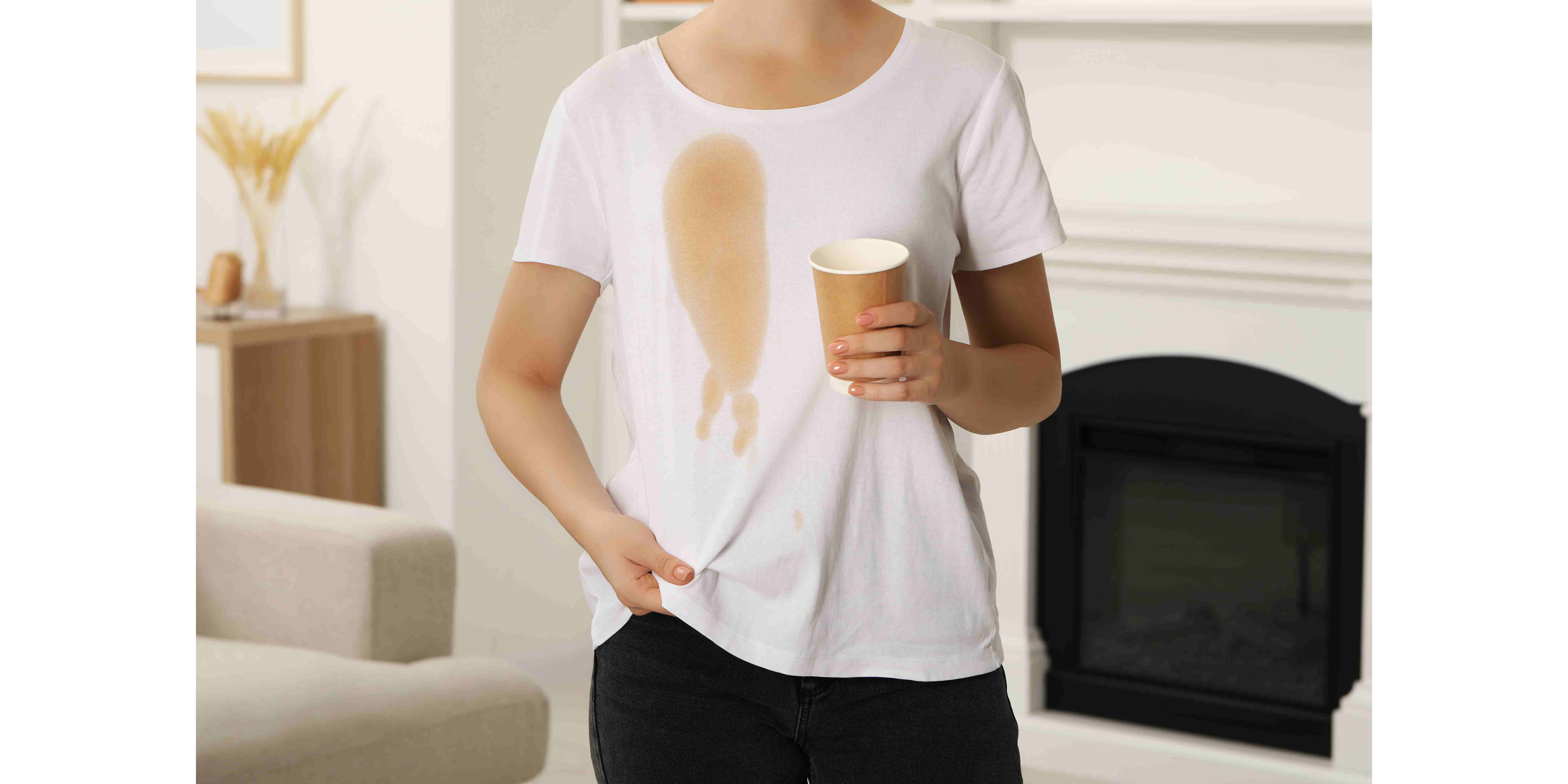 woman showing stain from coffee on her shirt indoors closeup