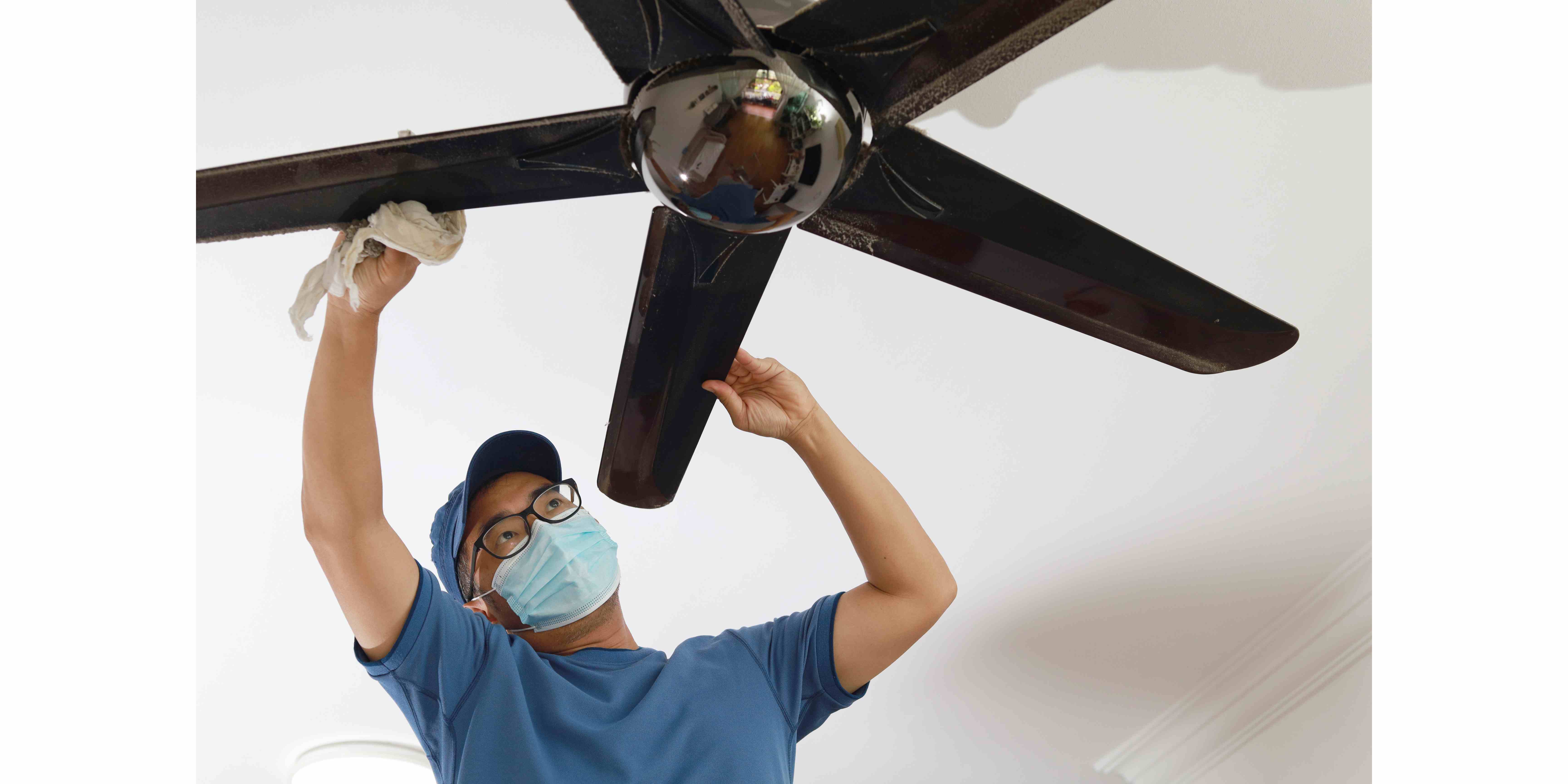 picture of a cleaner cleaning a ceiling fan